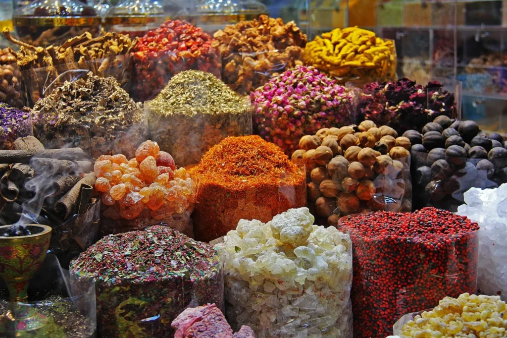 Vibrant collection of spices, herbs, and dried goods at a market stall, representing food import and export regulations, supply chain compliance, and operational considerations in the GCC.