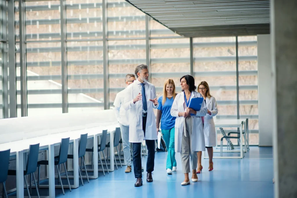 A group of doctors walking through a bright, modern hospital corridor, symbolizing healthcare compliance and regulatory guidance.